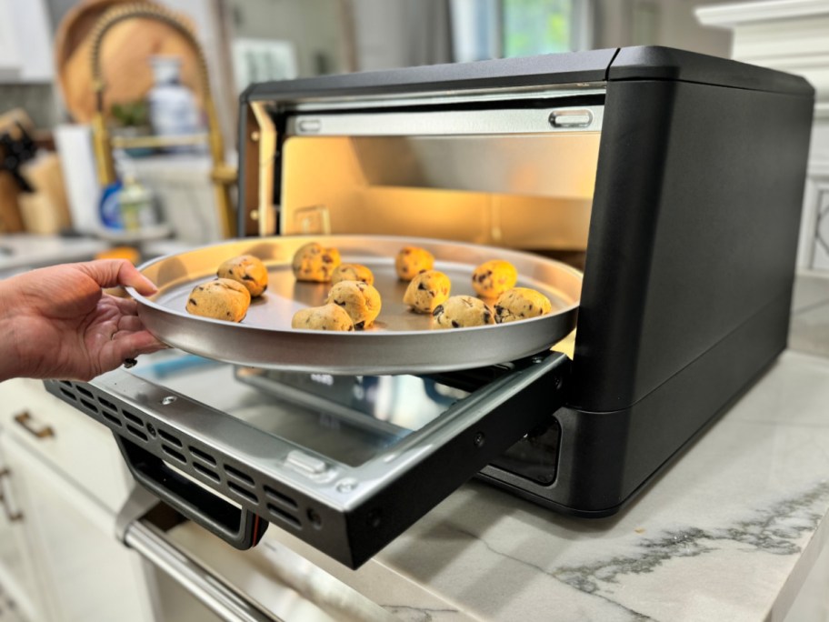 putting cookies into pizza oven