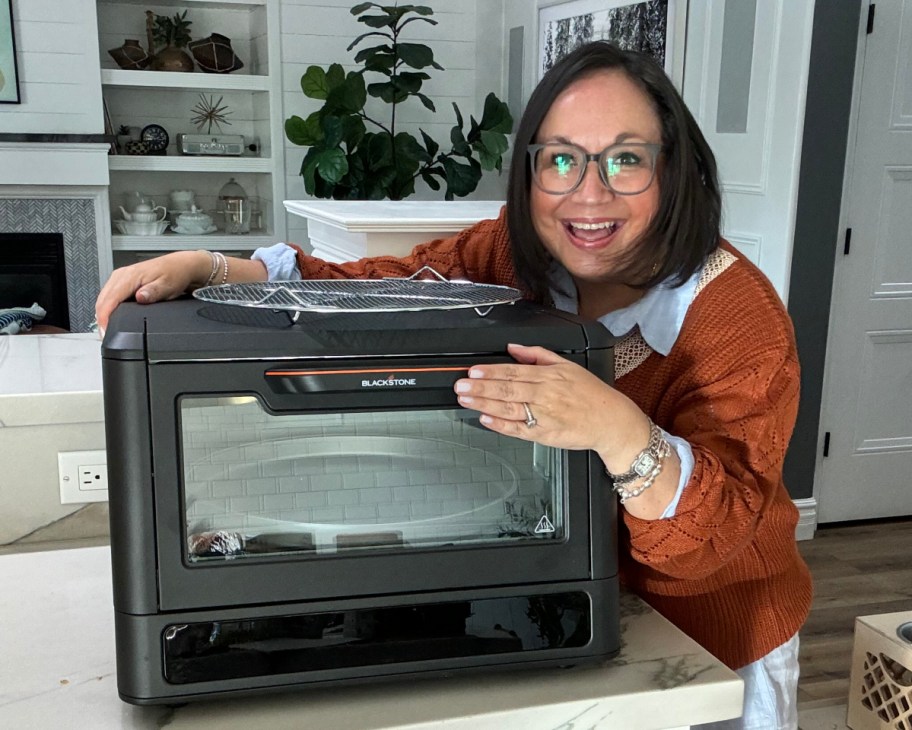 woman leaning over pizza oven