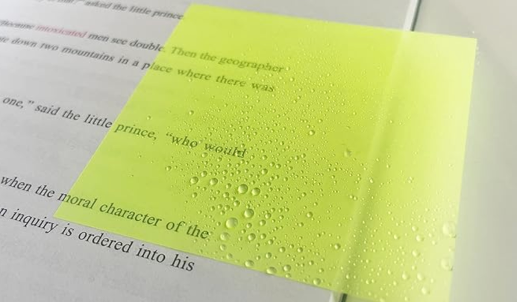 yellow clear sticky note on book with water droplets