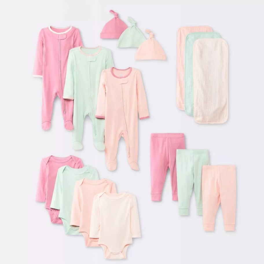 image of various baby clothing items in pinks, light greens, and peach solid colors