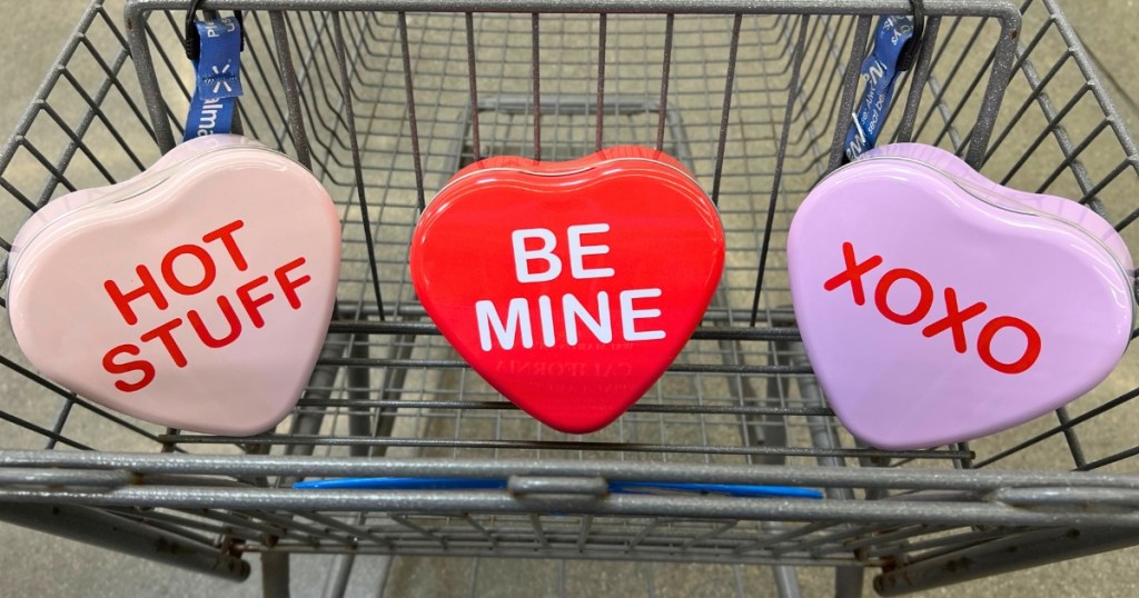 3 conversation hearts tin boxes in a walmart shopping cart. 