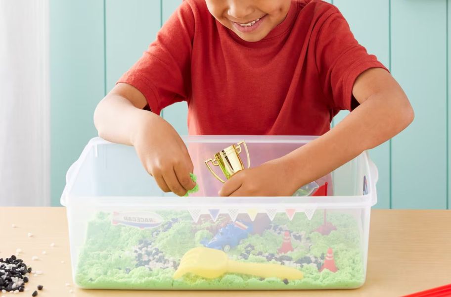 little kid playing with a sensory bin