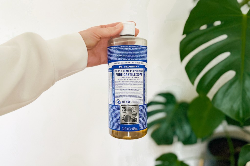 hand holding a bottle of dr bronners castile soap