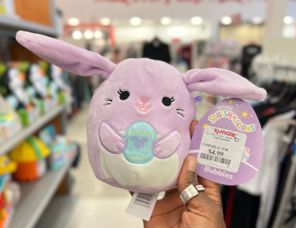 a womans hand holding a easter squishmallow bubbles