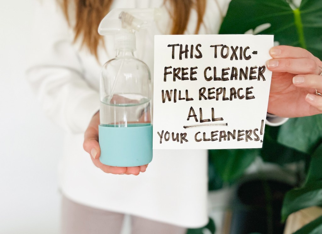 hand holding a sign about replacing all cleaners with one toxic free one