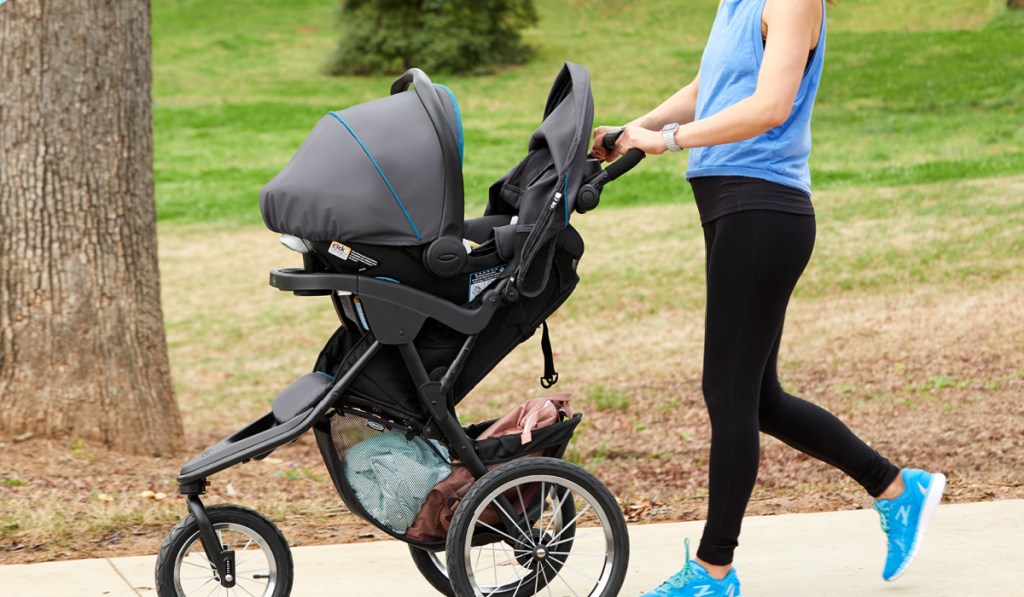 woman pushing graco jogging stroller with infant seat