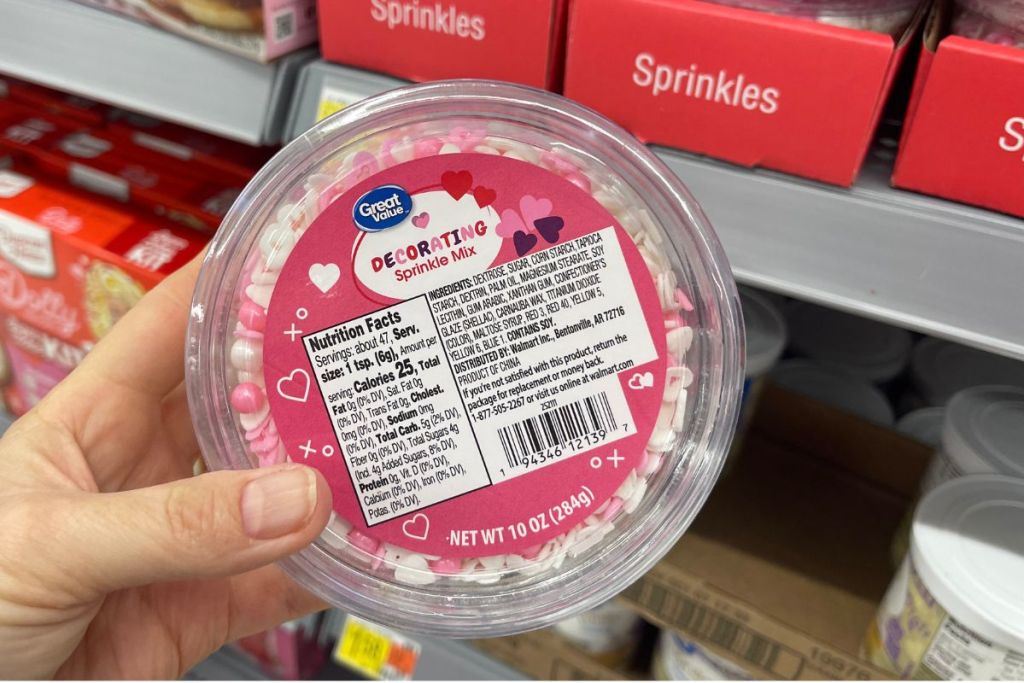 a womans hand holding a great value sprinkle mix bowl in store