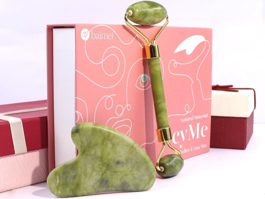 gua sha and jade roller in front of a pink box