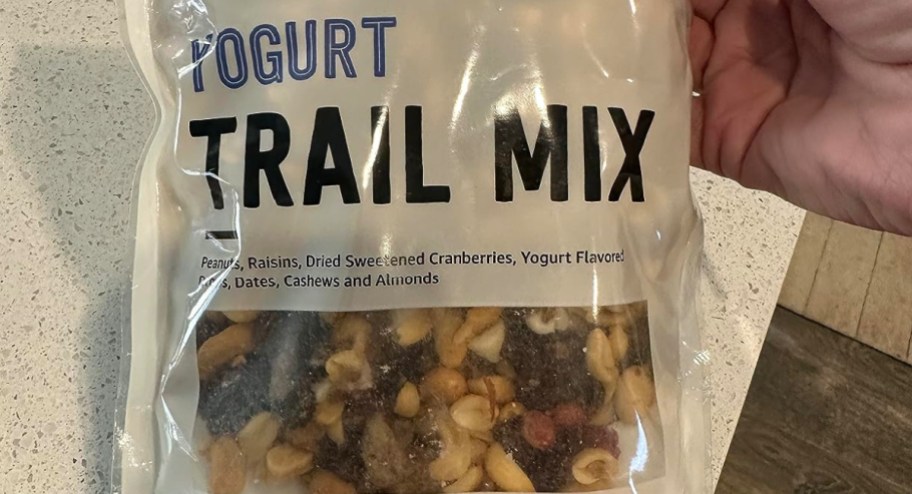 hand holding yogurt trail mix on the table