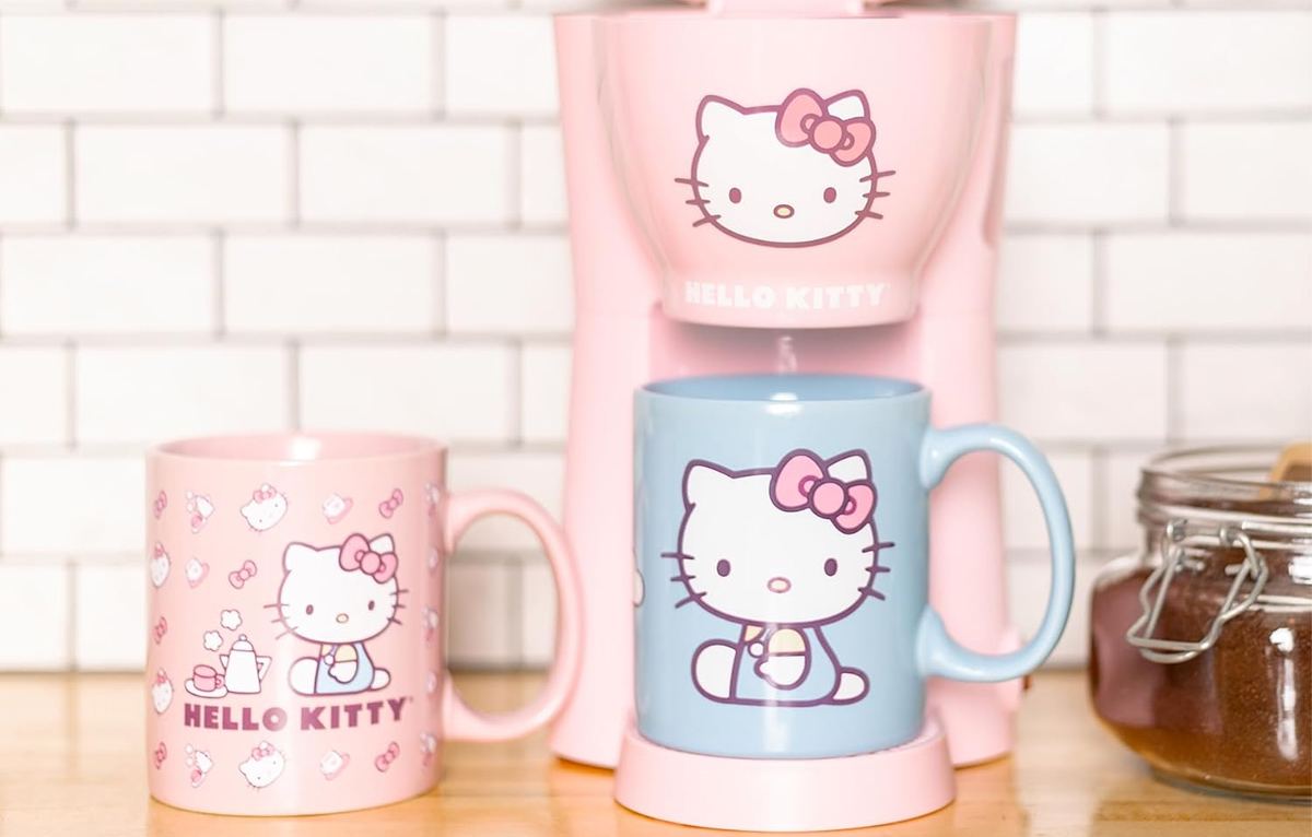pink hello kitty coffee maker with blue coffee mug on table with pink mug 