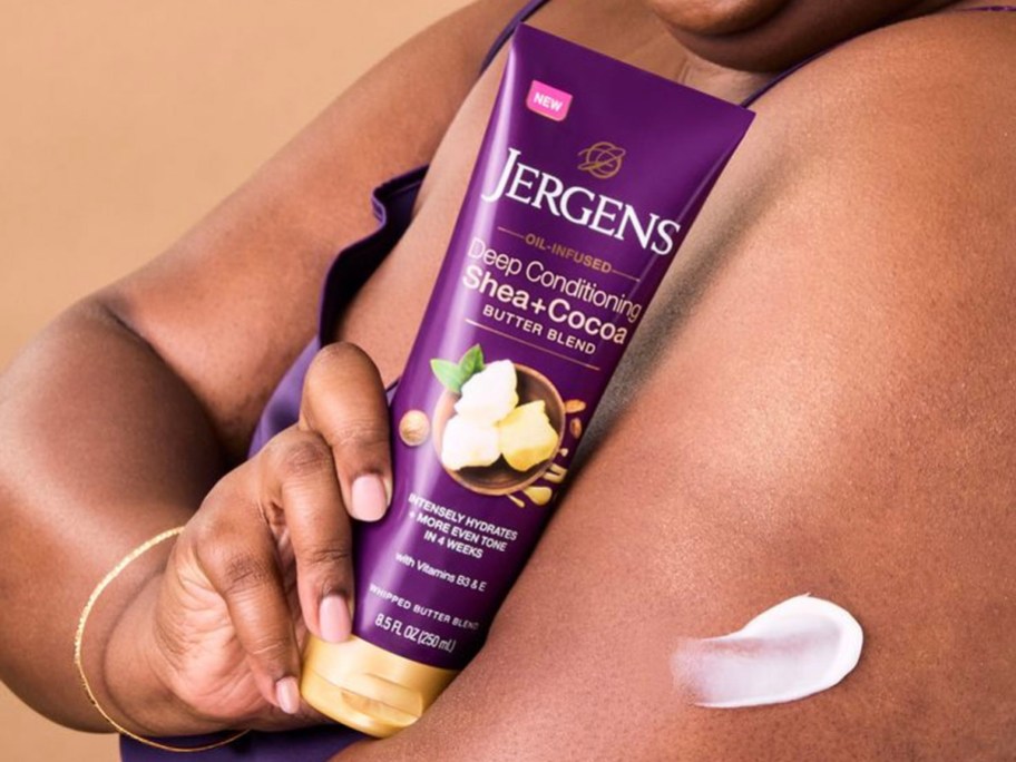 woman holding Jergens lotion with lotion on arm 