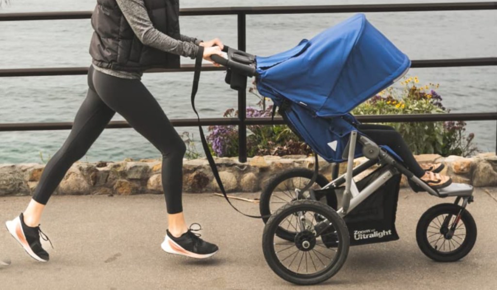 woman pushing blue joovy jogging stroller