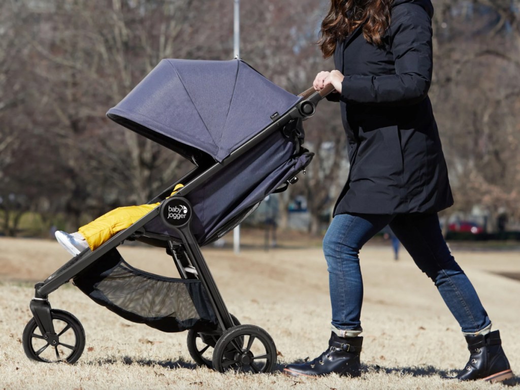 woman pushing baby jogger stroller with child in it