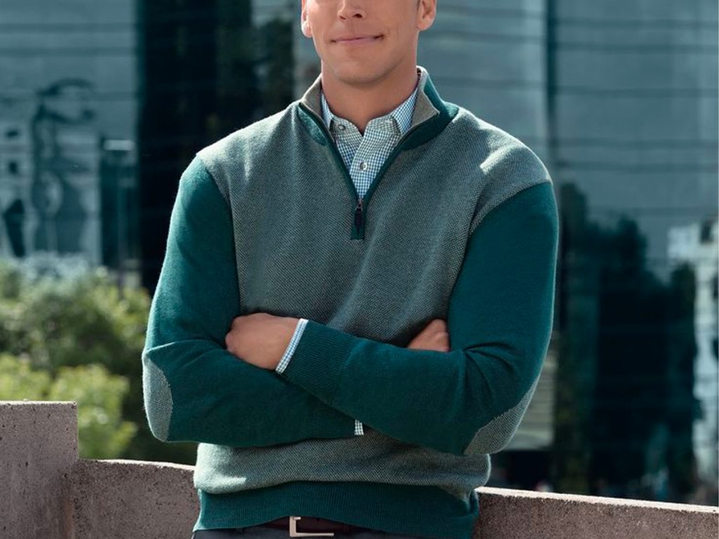 man wearing green sweater with arms crossed