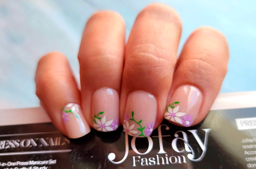 hand with flower joyfay nails on them holding kit
