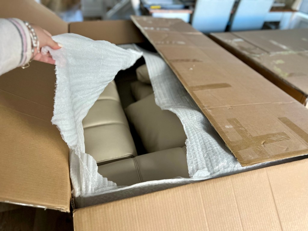 hand removing paper from sectional couch box