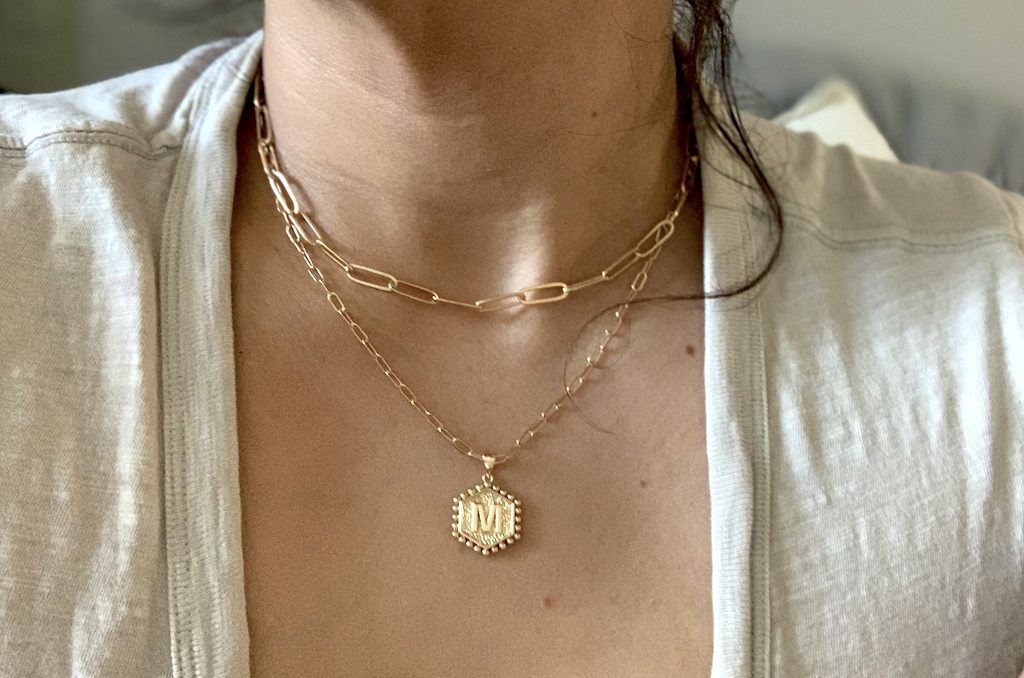 woman wearing layered gold initial necklace 