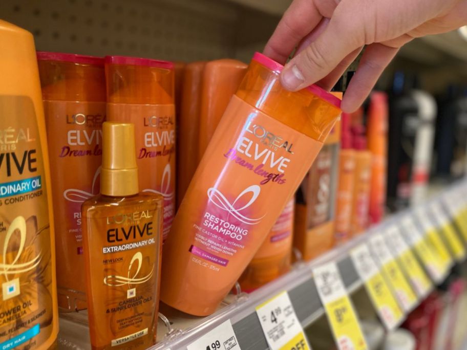 hand pulling elvive shampoo from shelf