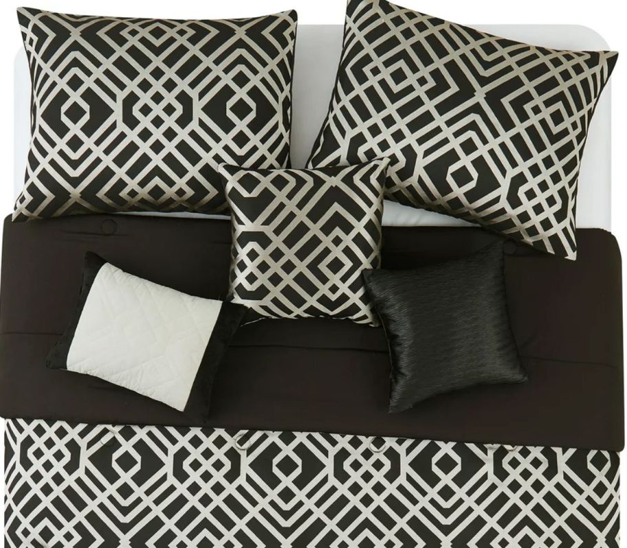 a black and gold geometric patterned comforter set on a bed