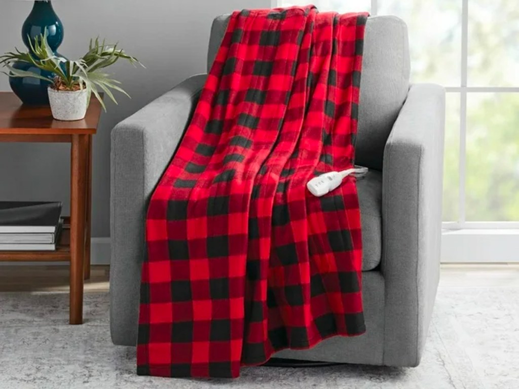 red and black plaid throw blanket on gray chair next to window