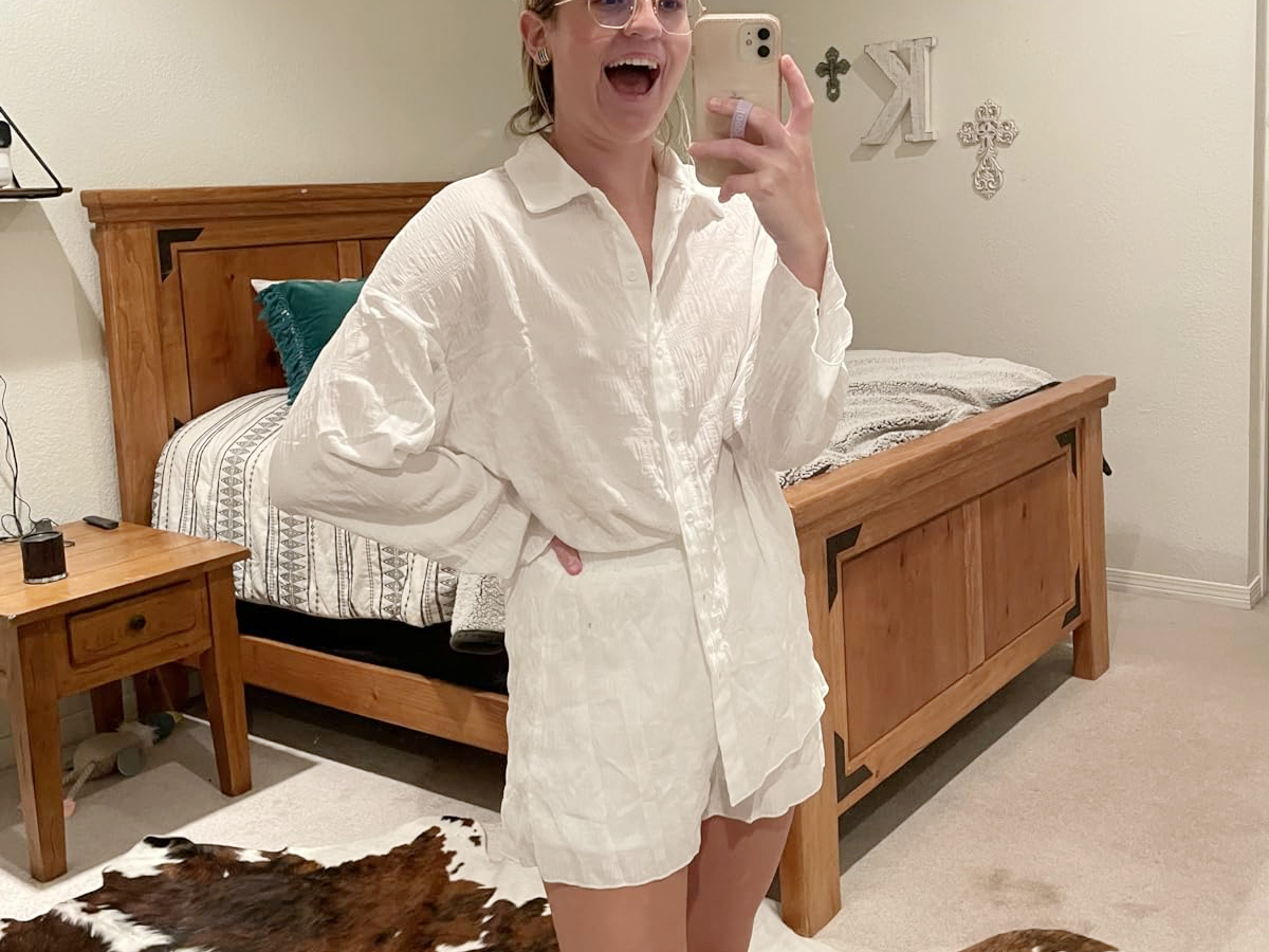 woman taking photo of herself in 2 piece white lounge set