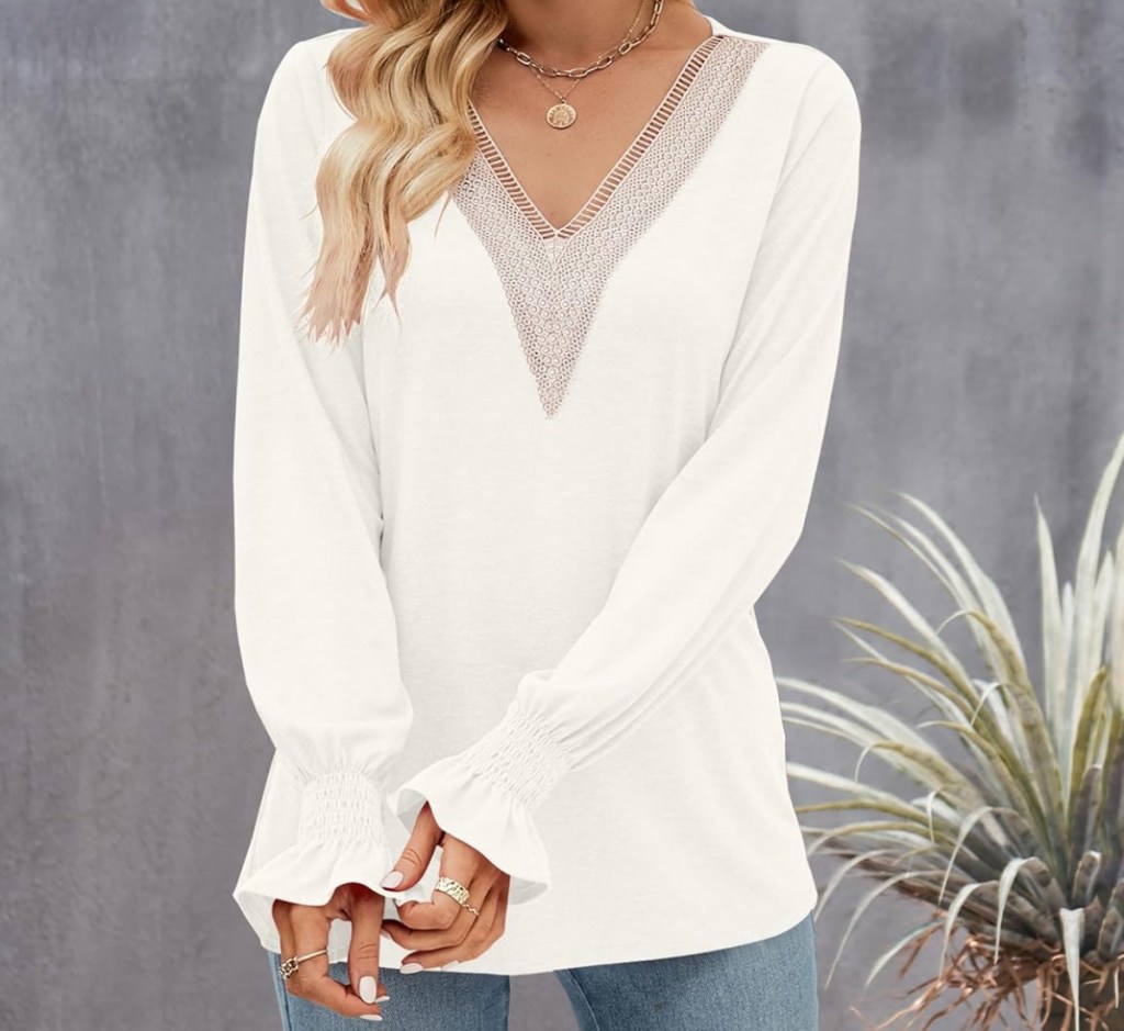 wearing a white sweater with a lace v-neck