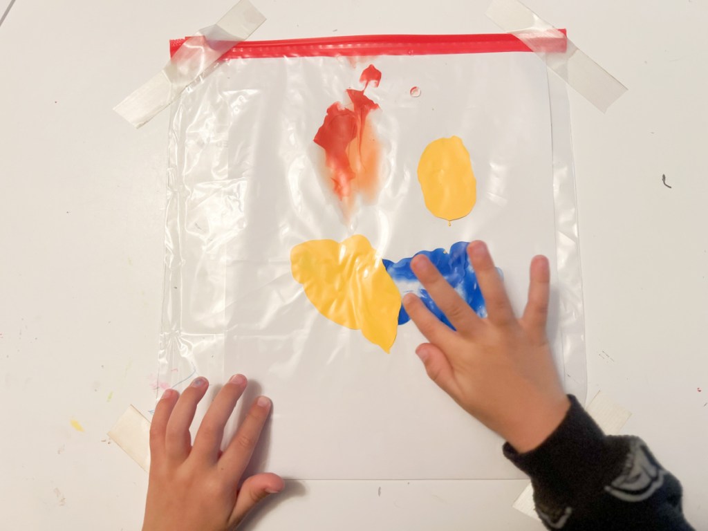 hands finger painting on ziploc bag