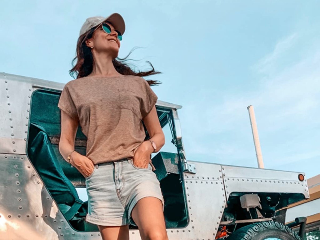 woman wearing tan shirt, shorts, and baseball hat