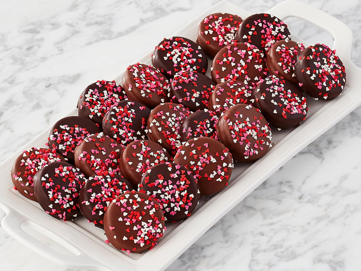 24 chocolate covered cookies with sprinkles on white plate