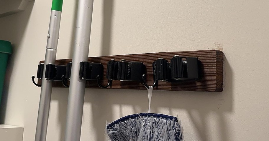 wooden mop and broom holder mounted on the wall