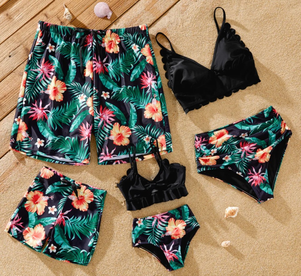 black and teal floral family swimsuits in a pile