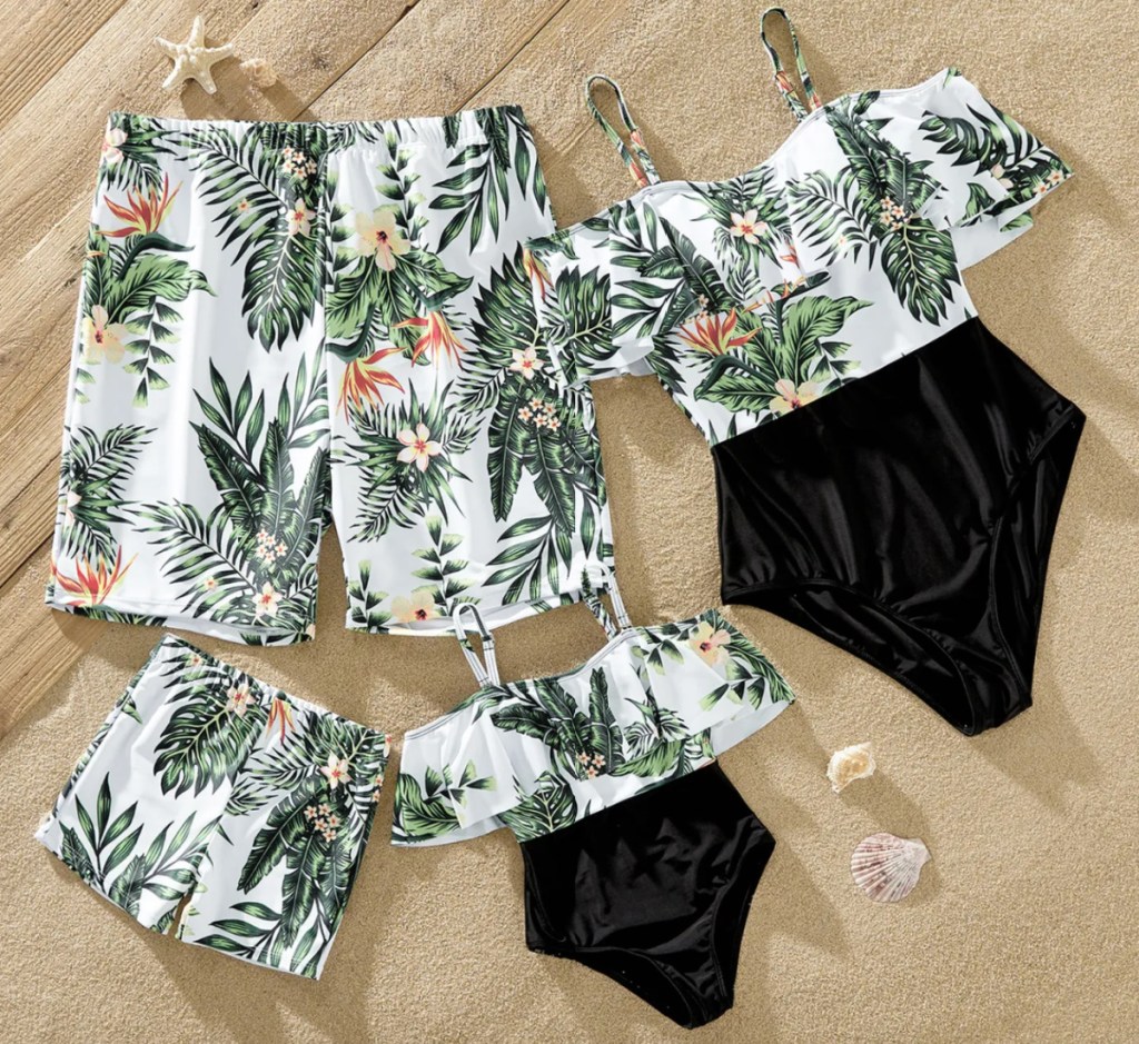 tropical print and black family swimsuits in a pile