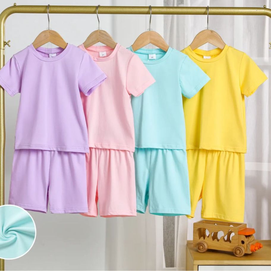 colorful kids 2-pic tshirt and shorts sets hanging on gold rack
