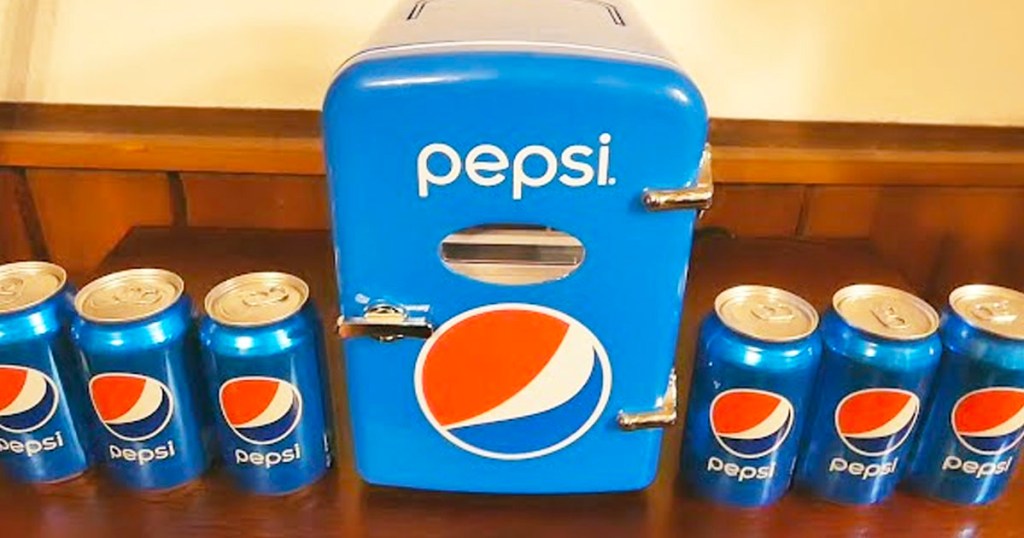 pepsi mini fridge with cans of pepsi next to it
