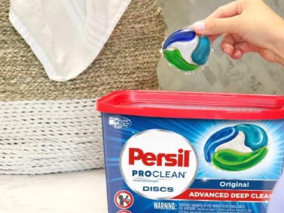 persil detergent pacs 38 count shown with womsns hand holding the pod