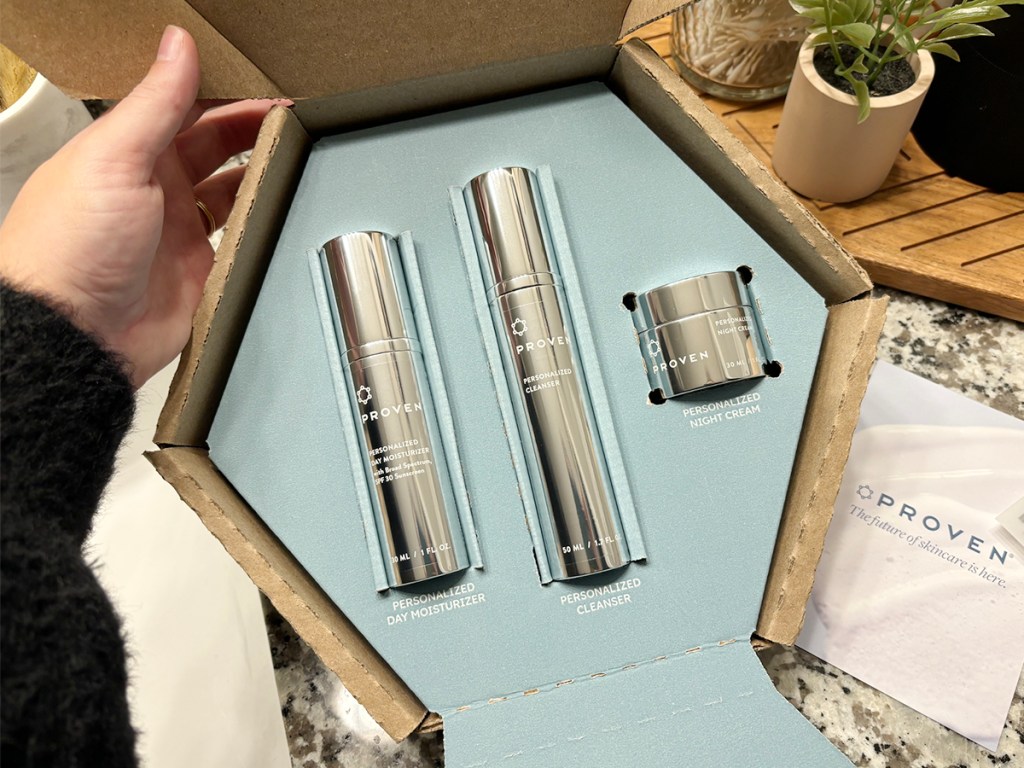 hand opening proven skincare box with three products inside 