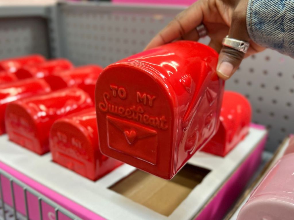 a woman's hand displaying a red ceramic valentines mailbox