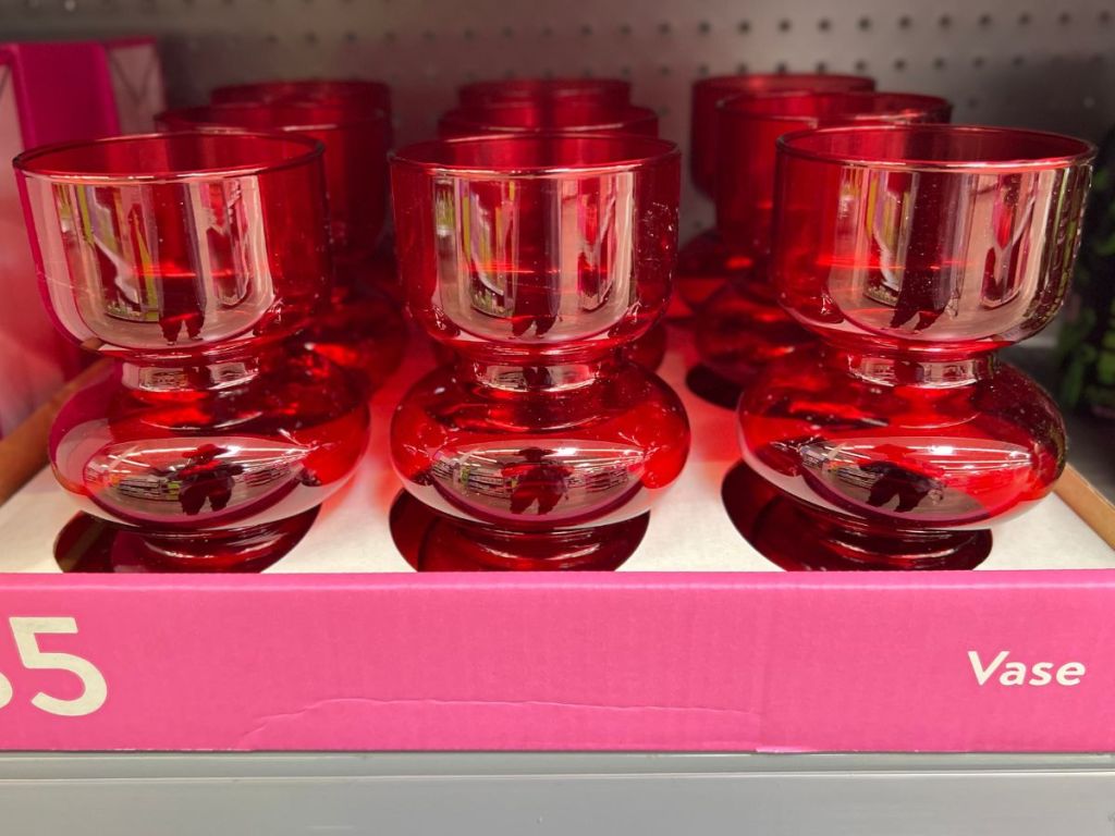 a tray of red glass vases on a shelf in a walmart store