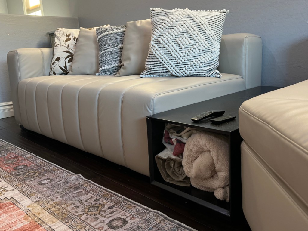 white leather sectional and black storage table
