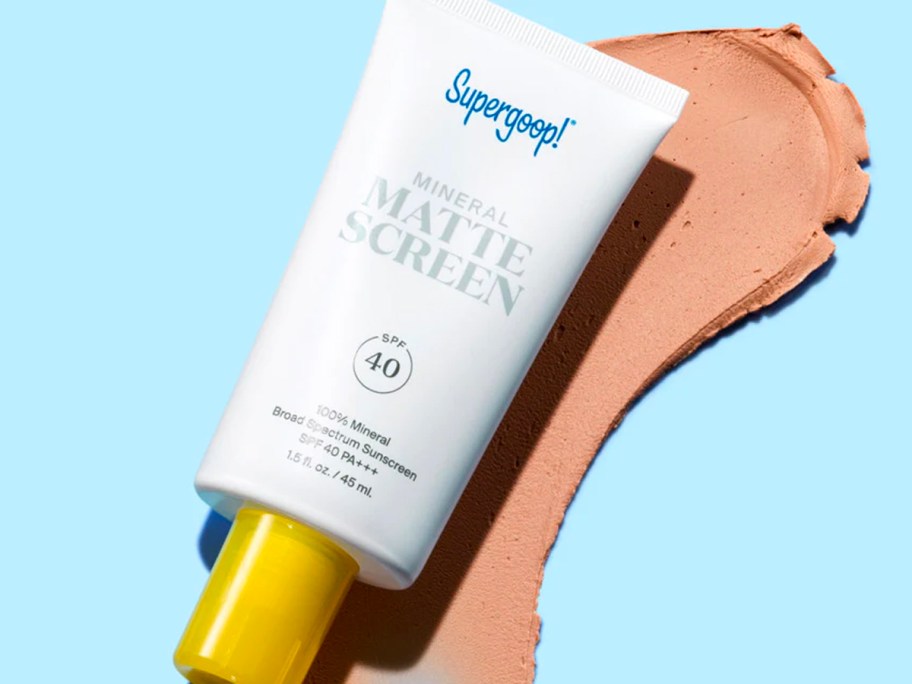supergoop mineral mattescreen spf 40 bottle with sunscreen laying under it