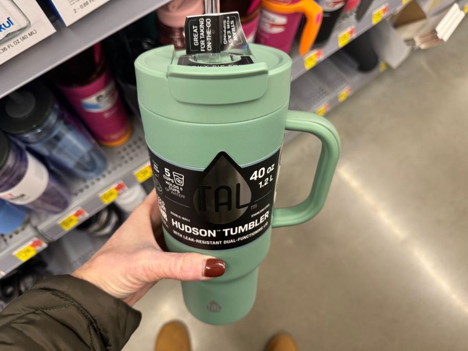 hand holding a green Tal 40 oz tumbler in store