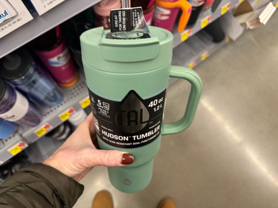 hand holding a green Tal 40 oz tumbler in store