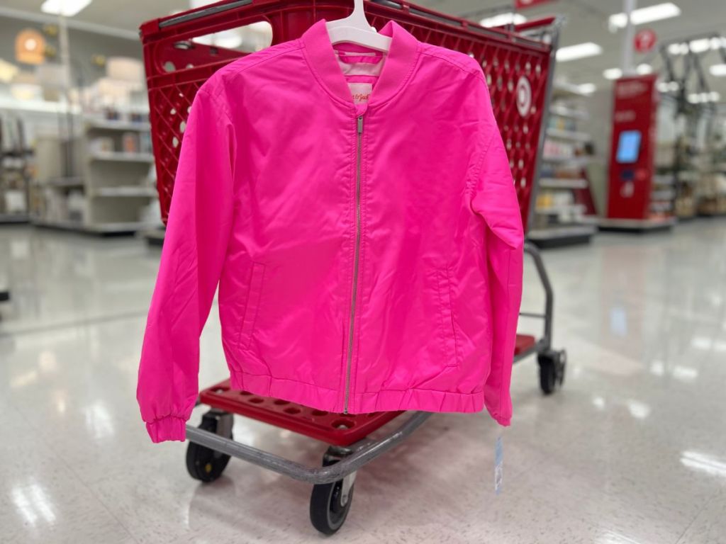 pink girl's bomber jacket hanging on Target cart