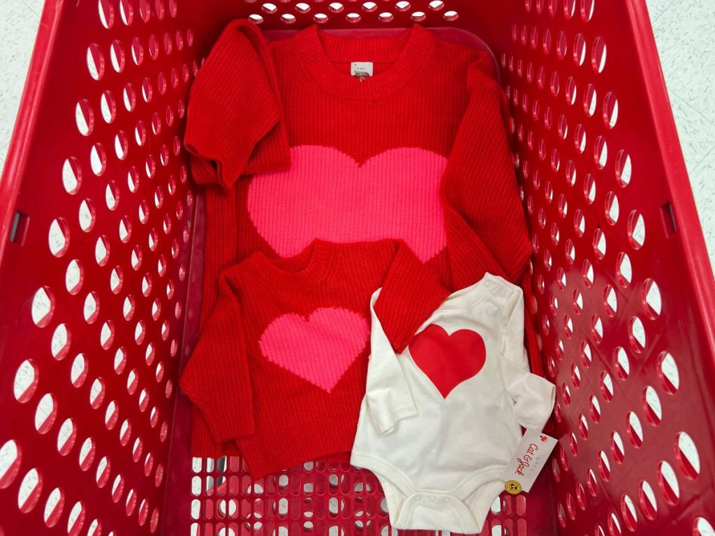Target shopping cart with women's & girls red sweaters with pink hearts and a cream baby onesie with a red heart