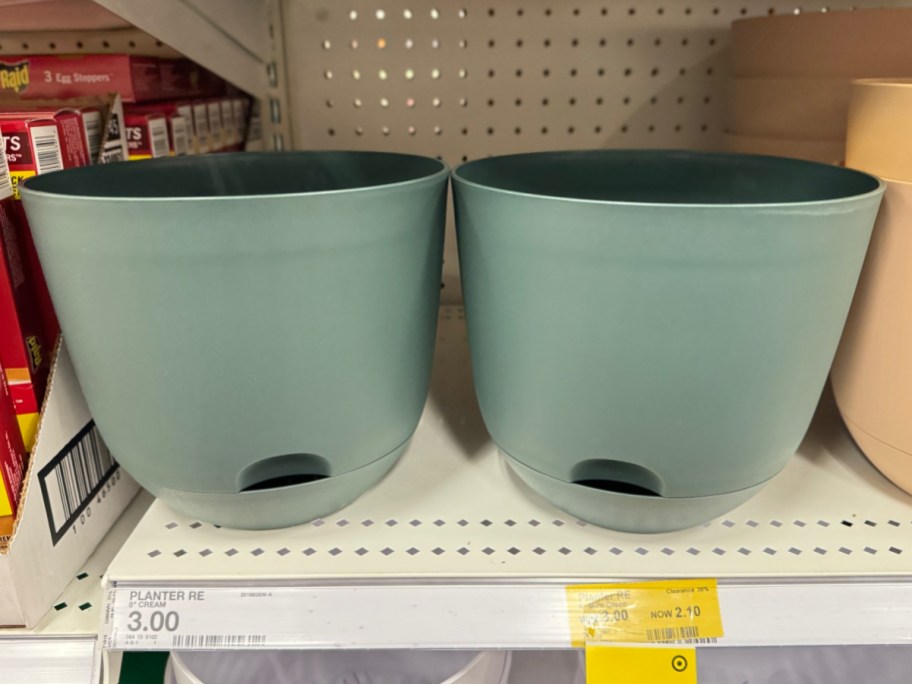 two green 8 inch planters displayed on a shelf