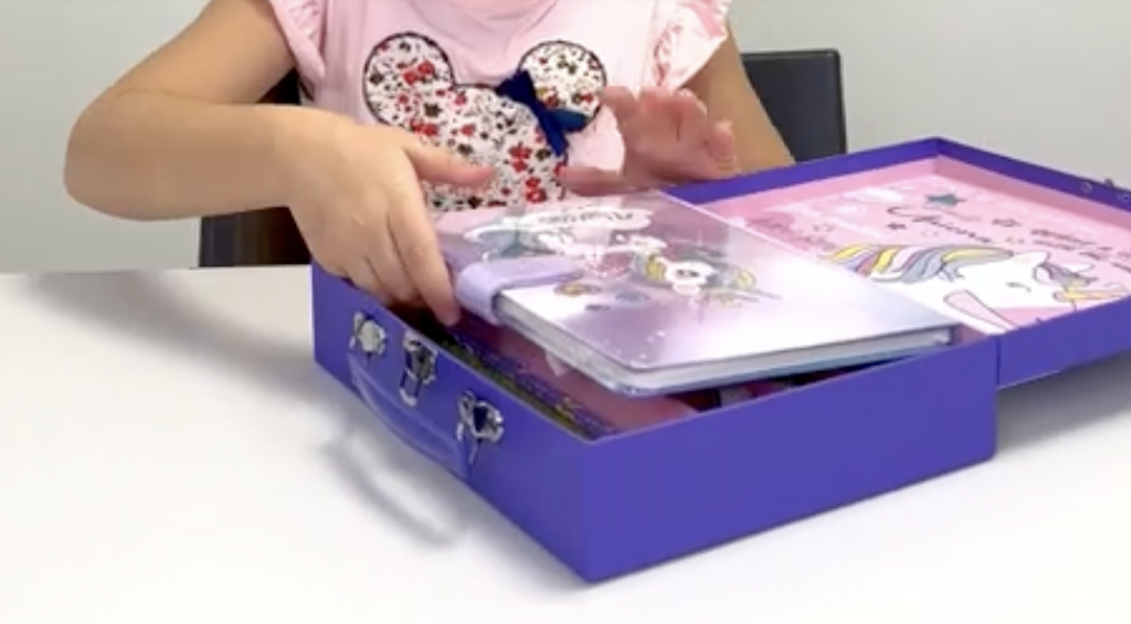 little girl opening Unicorn journal kit 
