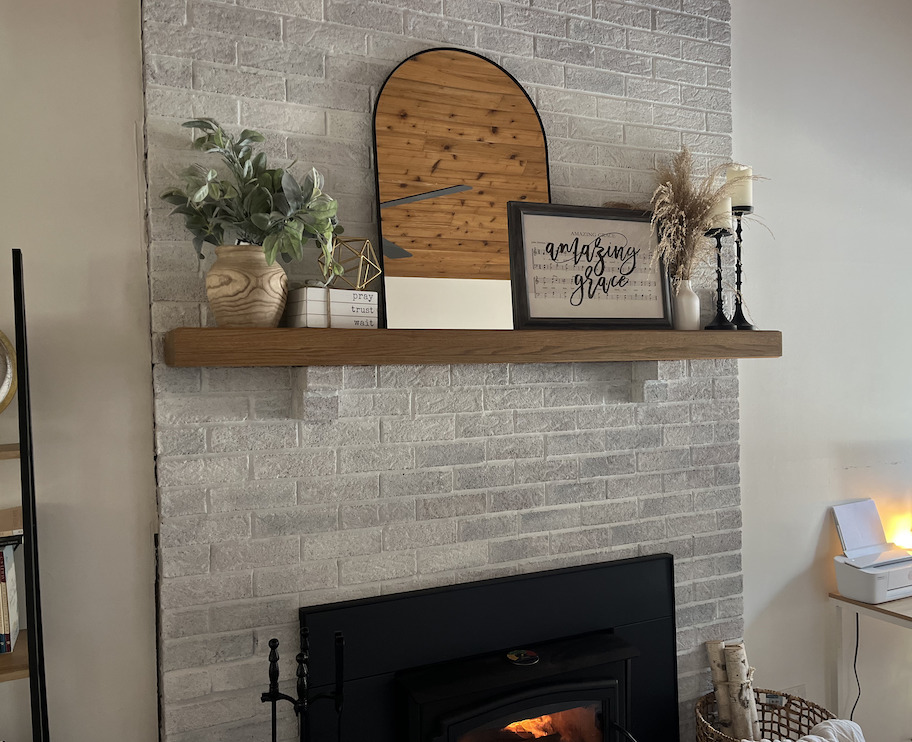 styled fireplace mantel with mirror art plant and books