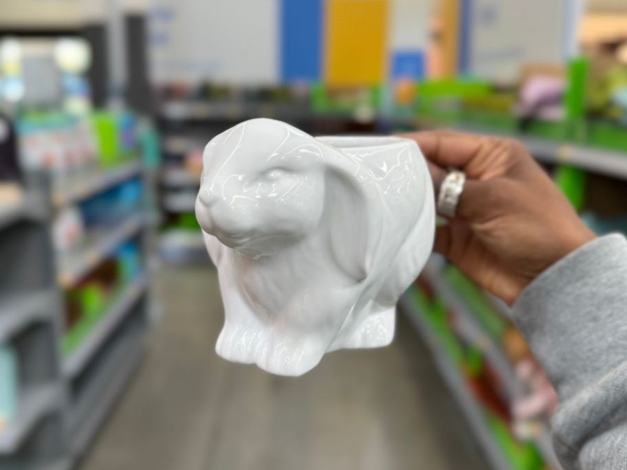hand holding a white rabbit shaped coffee mug