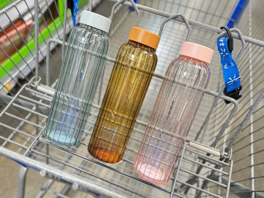blue, gold and pink glass water bottles in Walmart cart