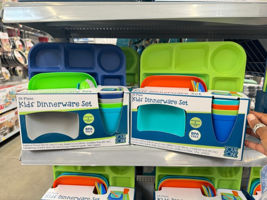 two different colors of Kid's 24 pc Dinnerware sets on shelf at Walmart